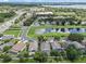 Aerial view of a home in a residential area, with a pond, green spaces, and a clear lake visible at 6720 Winder Lynne Ln, Orlando, FL 32819