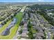 Scenic aerial view of a residential community and serene lake, lined with lush trees, homes, and green spaces at 6720 Winder Lynne Ln, Orlando, FL 32819