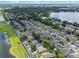 Panoramic aerial view of a residential community with green spaces, a pond, and neatly arranged homes on a sunny day at 6720 Winder Lynne Ln, Orlando, FL 32819