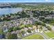 An aerial view showcases a neighborhood with neatly arranged homes, sidewalks, and verdant trees, complemented by a nearby lake at 6720 Winder Lynne Ln, Orlando, FL 32819