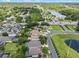 Scenic aerial view of a charming neighborhood with a peaceful lake, tree-lined roads, and well-manicured lawns at 6720 Winder Lynne Ln, Orlando, FL 32819
