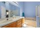 Bright bathroom features a double sink vanity, soaking tub, and glass shower at 6720 Winder Lynne Ln, Orlando, FL 32819