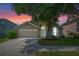 Charming home featuring a two-car garage, manicured lawn, and mature tree shading the front yard at 6720 Winder Lynne Ln, Orlando, FL 32819