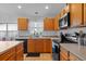 Modern kitchen featuring stainless steel appliances, oak cabinets, and tile flooring at 6720 Winder Lynne Ln, Orlando, FL 32819