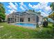 Exterior view of a home with a screened-in pool and well-maintained yard, ideal for outdoor living at 6720 Winder Lynne Ln, Orlando, FL 32819