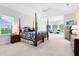 Spacious main bedroom with a four-poster bed, sitting area, and natural light from large windows at 740 Bear Creek Cir, Winter Springs, FL 32708