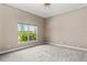 Bright bedroom featuring a large window view, neutral colors, and a ceiling fan at 800 Sterling Chase Dr, Port Orange, FL 32128