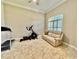 Versatile bonus room with a leather loveseat, exercise equipment, and a bright window with plantation shutters at 800 Sterling Chase Dr, Port Orange, FL 32128