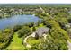 Aerial view of luxury home, large lot, lake, and meticulously manicured lawns at 8542 Eden Park Rd, Orlando, FL 32810