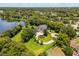 Scenic aerial view of an estate home, showcasing landscaping and lake views at 8542 Eden Park Rd, Orlando, FL 32810