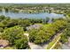 Aerial view of estate home with lake, lush landscaping, and mature trees at 8542 Eden Park Rd, Orlando, FL 32810