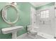 Bathroom with a vintage sink, black and white checkered floors, white tile shower, and a fresh green painted wall at 8542 Eden Park Rd, Orlando, FL 32810