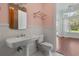 Bathroom featuring a pedestal sink, wainscoting, and access to the bedroom at 8542 Eden Park Rd, Orlando, FL 32810