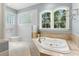 Relaxing bathroom featuring a soaking tub with jets, a walk-in shower, and natural light at 8542 Eden Park Rd, Orlando, FL 32810