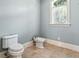 Clean half-bathroom with toilet, bidet, tile floor and window at 8542 Eden Park Rd, Orlando, FL 32810