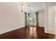 Light-filled bedroom features hardwood floors, detailed trim, and windows dressed with green and white checked curtains at 8542 Eden Park Rd, Orlando, FL 32810