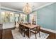 Dining room with chandelier, open to living area, complemented by hardwood floors at 8542 Eden Park Rd, Orlando, FL 32810