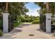 View of the property through open gates, highlighting meticulous landscaping at 8542 Eden Park Rd, Orlando, FL 32810