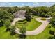 Front exterior of estate home with circular driveway and landscaped garden at 8542 Eden Park Rd, Orlando, FL 32810