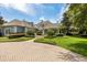 Front exterior view of home with circular brick driveway and professionally manicured front lawn at 8542 Eden Park Rd, Orlando, FL 32810