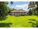 Beautiful two-story home with a large lawn, columns, and serene outdoor space at 8542 Eden Park Rd, Orlando, FL 32810