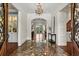 Grand foyer features marble floors, chandelier, and arched doorways at 8542 Eden Park Rd, Orlando, FL 32810