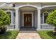 Elegant front entrance with columns, double doors, and manicured bushes at 8542 Eden Park Rd, Orlando, FL 32810