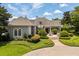 Front exterior of beautiful estate home featuring manicured gardens and trees at 8542 Eden Park Rd, Orlando, FL 32810
