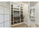Hallway featuring custom built-in shelves, decorative chandelier, and archway to a room with black and white checkered floors at 8542 Eden Park Rd, Orlando, FL 32810