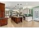 Kitchen boasts a large island, stainless appliances, custom cabinets, and access to another room at 8542 Eden Park Rd, Orlando, FL 32810