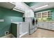 Modern laundry room with built-in cabinets, a utility sink, and updated appliances at 8542 Eden Park Rd, Orlando, FL 32810