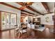 Open living room with wood beams, hardwood floors, bar area, and large glass doors at 8542 Eden Park Rd, Orlando, FL 32810