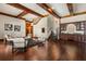 Open-concept living room with wood beam ceilings, hardwood floors, wet bar, and a staircase with decorative ironwork at 8542 Eden Park Rd, Orlando, FL 32810