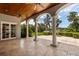 Relaxing covered patio with columns, ceiling fans and scenic backyard views at 8542 Eden Park Rd, Orlando, FL 32810