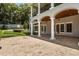 Covered patio with travertine tile, columns, and outdoor seating area at 8542 Eden Park Rd, Orlando, FL 32810