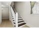 Traditional staircase with dark wood treads, white risers, and a decorative bird statue at 8542 Eden Park Rd, Orlando, FL 32810