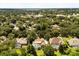 An aerial view of the property featuring a screened-in pool surrounded by lush greenery and neighborhood homes at 8800 Torey Pines Ter, Orlando, FL 32819