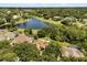 Stunning aerial view of the property with a serene lake and lush green surroundings at 8800 Torey Pines Ter, Orlando, FL 32819