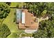 An aerial view of the home and backyard, showing a pool, patio, mature trees, and driveway at 8800 Torey Pines Ter, Orlando, FL 32819