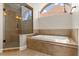 Bathroom showcasing garden tub with tile surround, and glass-enclosed shower at 8800 Torey Pines Ter, Orlando, FL 32819