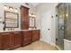 Bathroom with double sinks, granite countertops, and a glass enclosed shower at 8800 Torey Pines Ter, Orlando, FL 32819