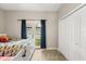 Bedroom features carpet flooring, closet, and access to the backyard at 8800 Torey Pines Ter, Orlando, FL 32819