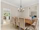 Formal dining room with stylish chairs and modern chandelier, flowing into the living area at 8800 Torey Pines Ter, Orlando, FL 32819