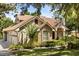 Side view of lovely home with attached garage, manicured landscaping, and brick and stucco exterior at 8800 Torey Pines Ter, Orlando, FL 32819