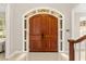 Elegant foyer showcasing double doors, marble flooring, and classic architectural details at 8800 Torey Pines Ter, Orlando, FL 32819