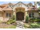 Inviting front entrance featuring an arched doorway, brick facade, and manicured landscaping at 8800 Torey Pines Ter, Orlando, FL 32819