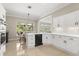 Kitchen with white cabinets, an island, and views of the breakfast nook and screened pool area at 8800 Torey Pines Ter, Orlando, FL 32819