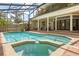 A screened-in pool and hot tub, with brick decking and an outdoor seating area at 8800 Torey Pines Ter, Orlando, FL 32819