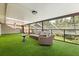 Relax in this sunroom, featuring artificial turf flooring, comfortable seating, and a full screen enclosure, making indoor, outdoor living easy at 8800 Torey Pines Ter, Orlando, FL 32819