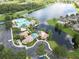 An aerial view showcasing the pool, clubhouse, lake, and surrounding neighborhood at 9053 Lee Vista Blvd # 1404, Orlando, FL 32829